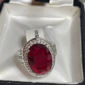 Ruby woman’s  ring with CZ surrounding the stone and part of the band. Size 9